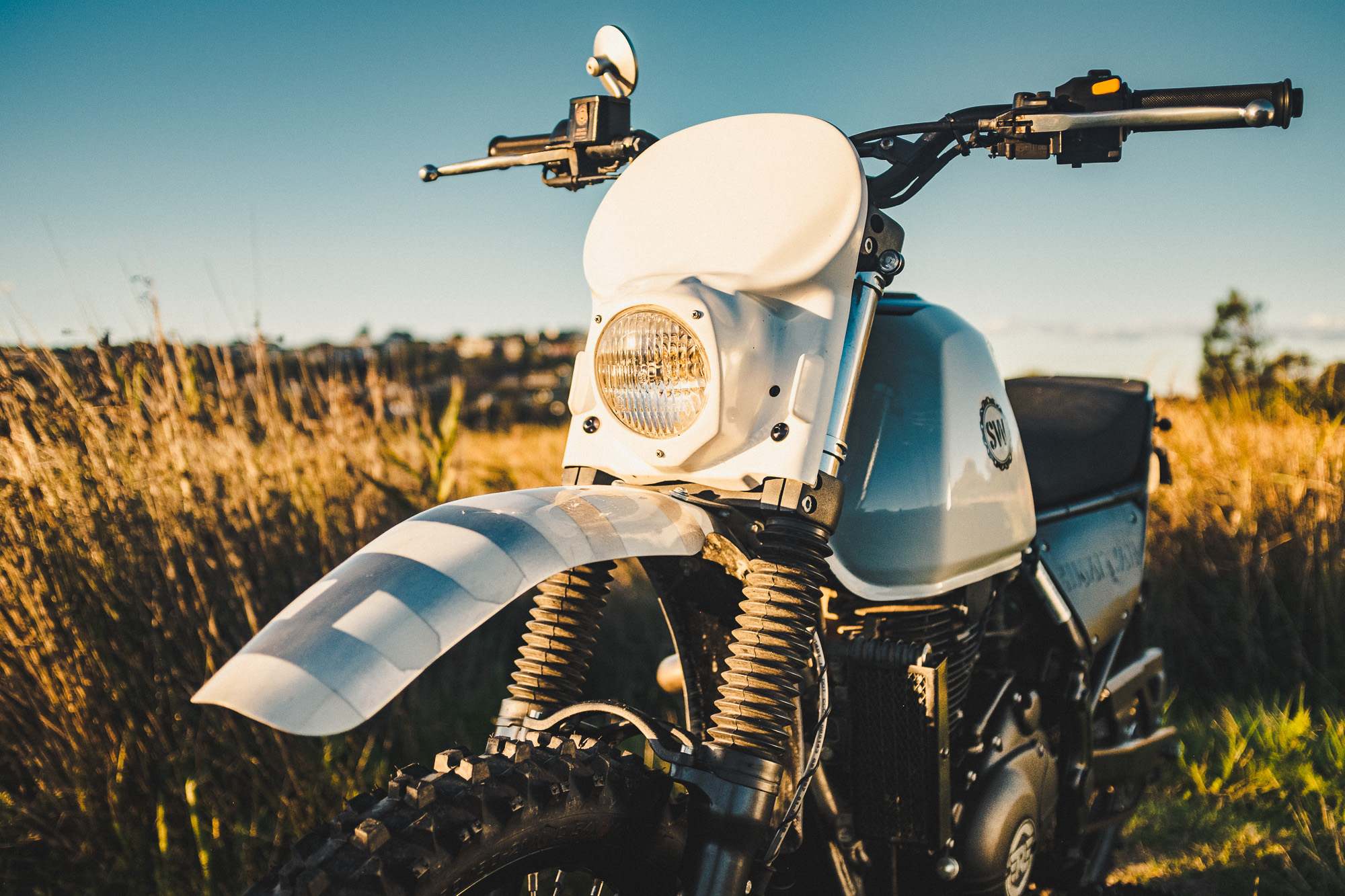Schlachtwerk's Royal Enfield Himalayan Enduro Custom on a beach at sunset in Sydney