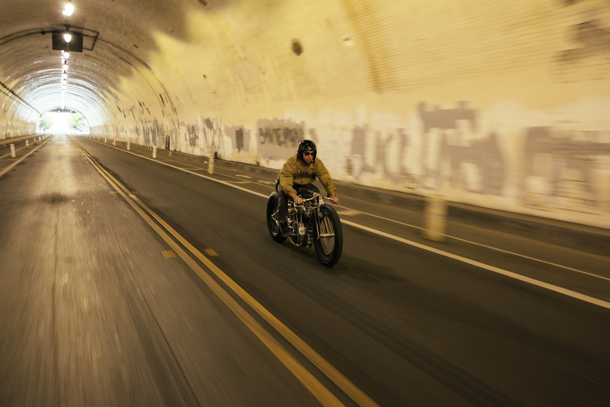 Custom bike builder Max Hazan rides his motorcycle in a tunnel