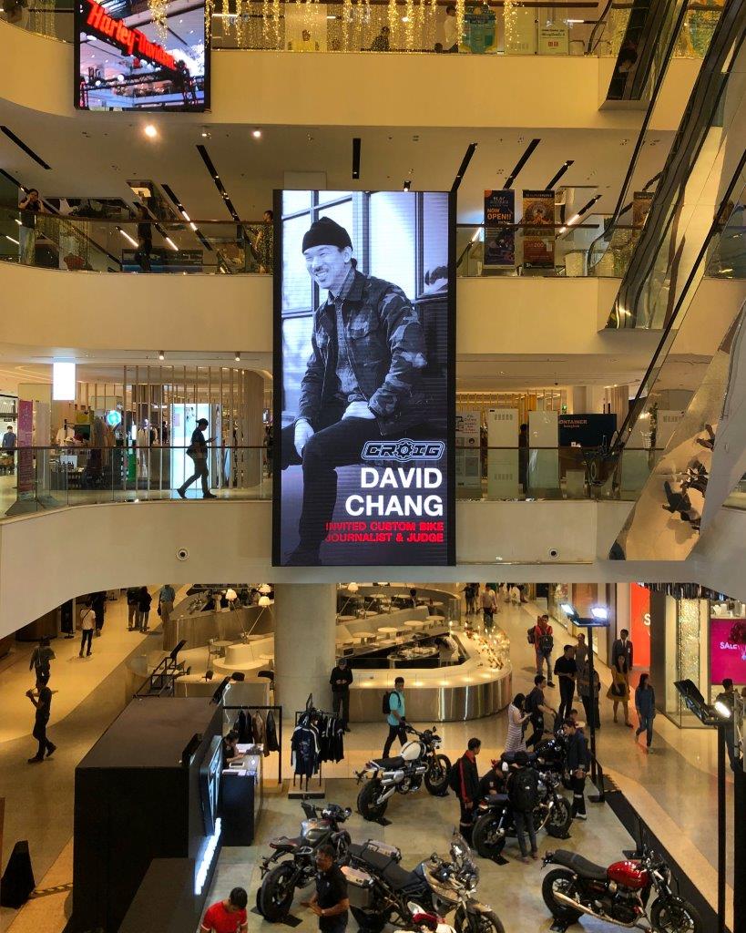 David Chang's photo on a jumbotron screen at a shopping mall