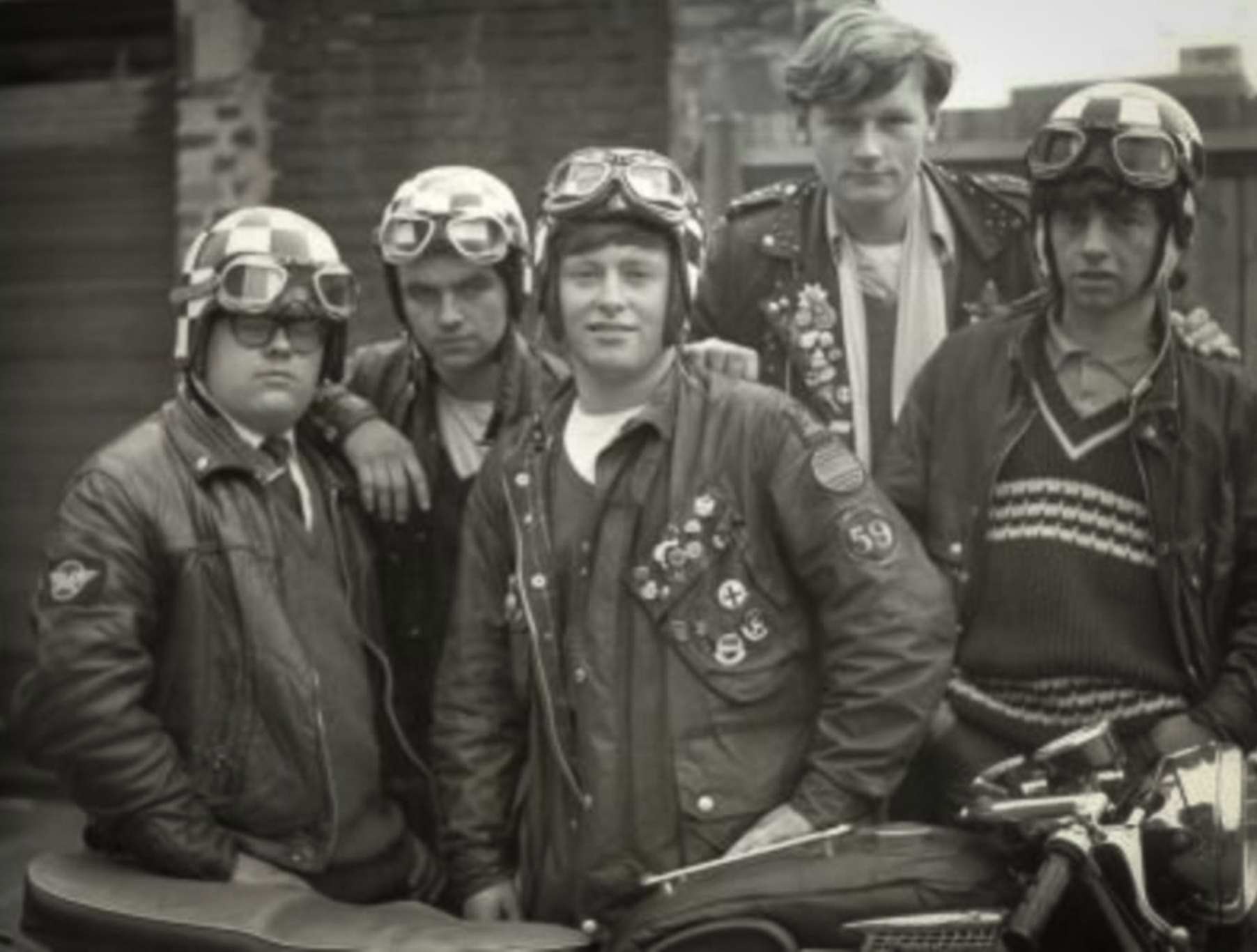 British Cafe Racers in London in the late 1950s stand around a motorcycle