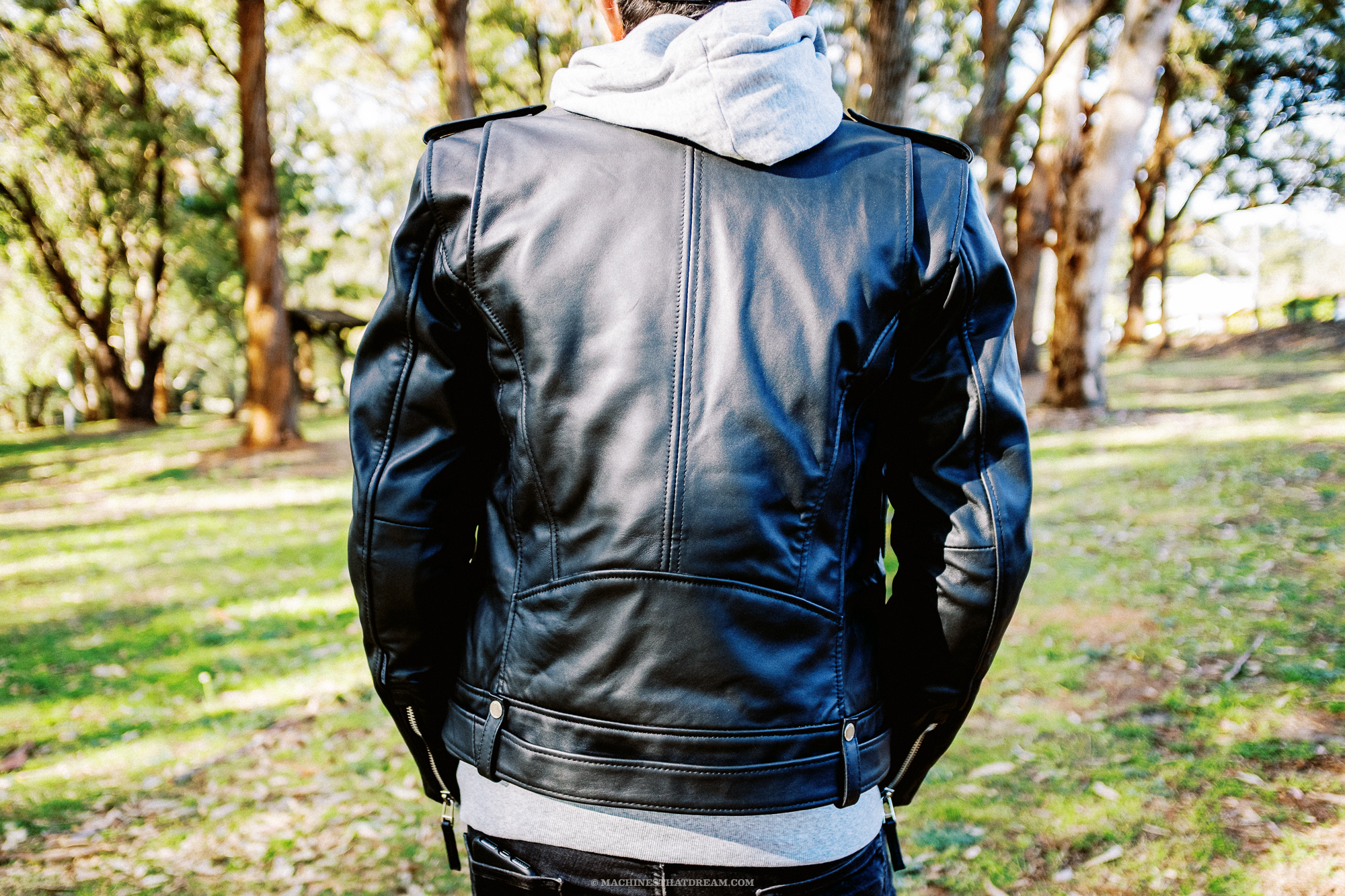 A strange man in a park wearing the Boda Skin's 'Voyager' leather motorcycle jacket