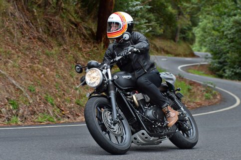 Man rides Triumph motorcycle through forest road in Australia