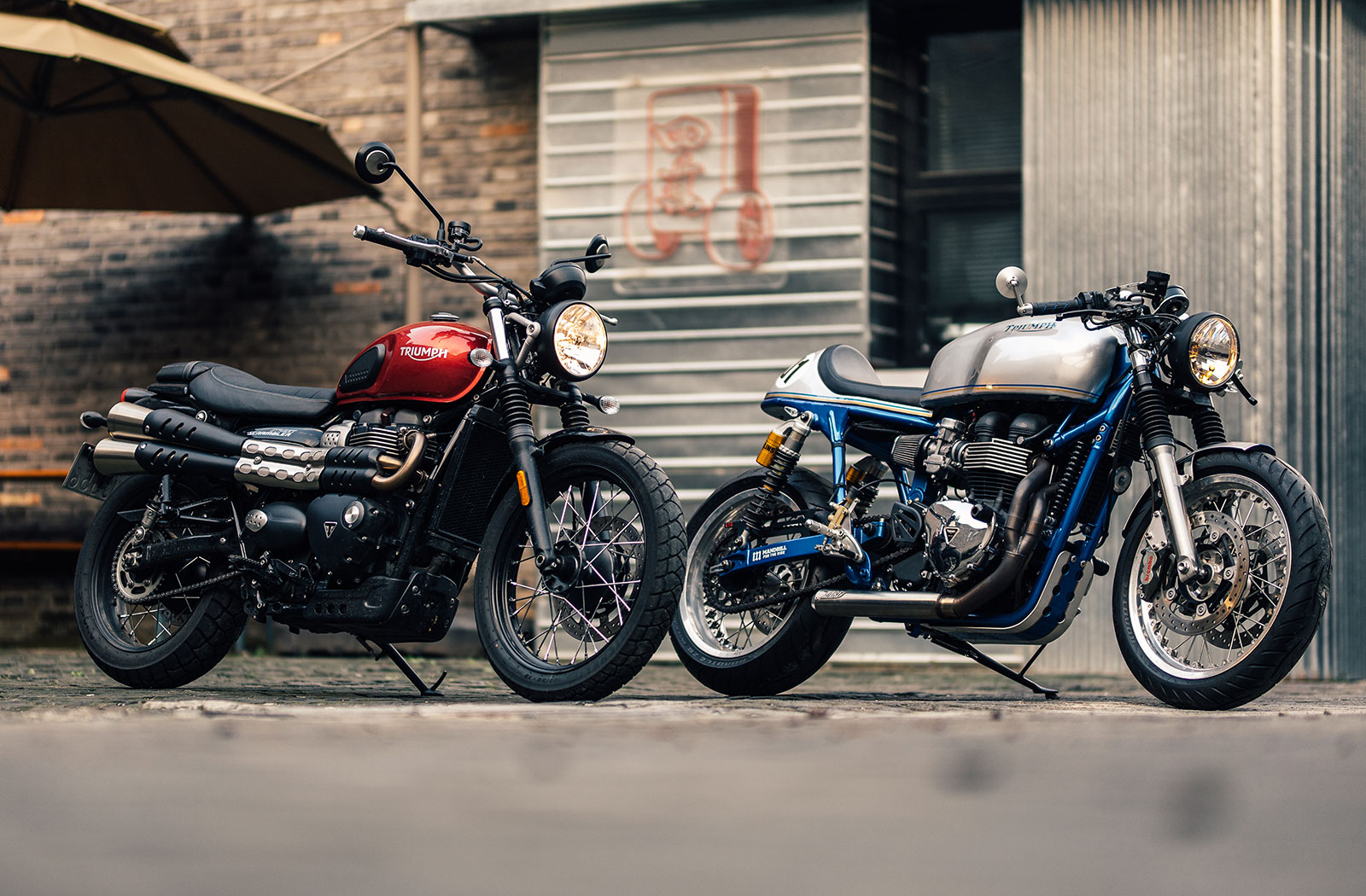 A watercooled Bonneville sitting beside an air-cooled T100 cafe racer