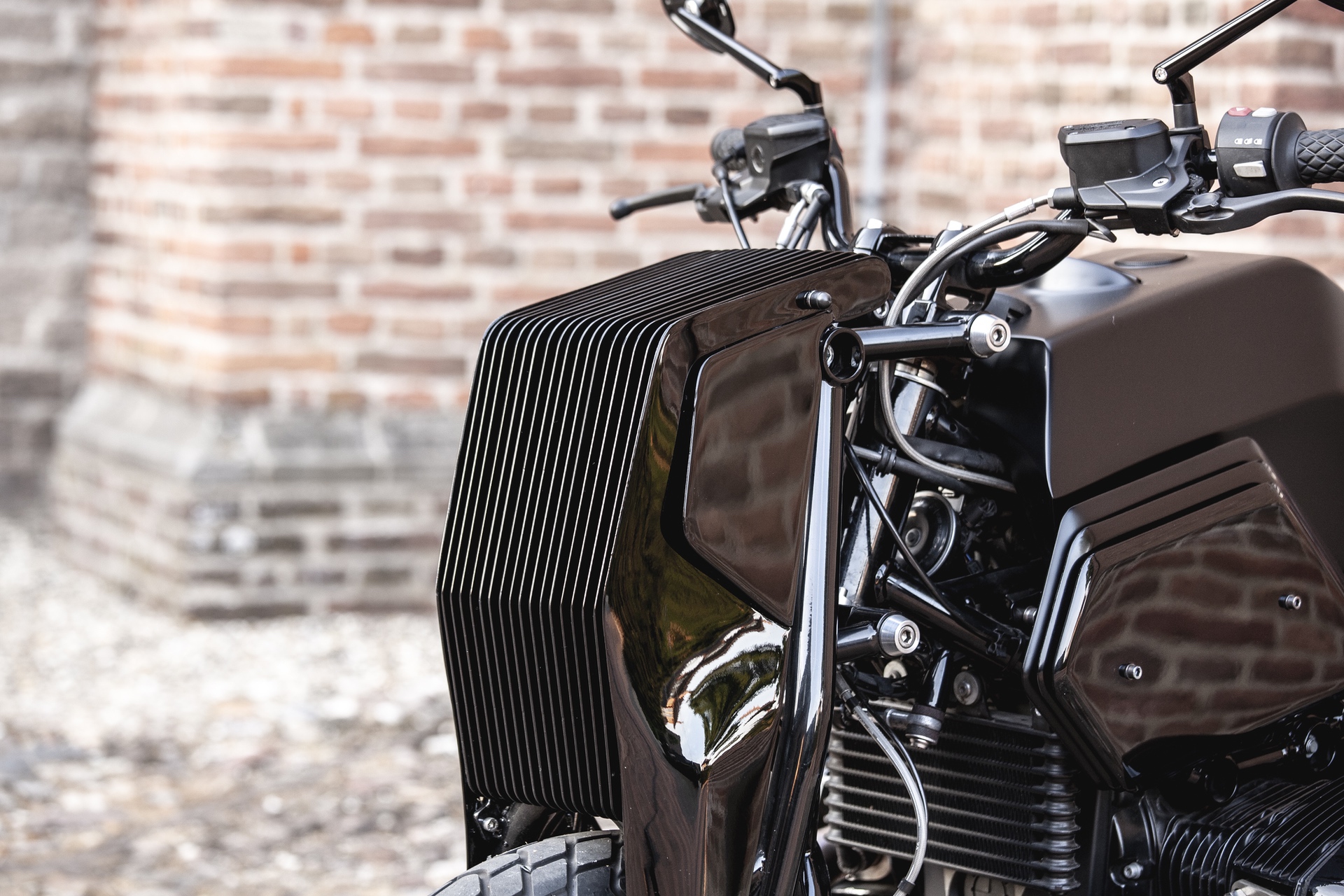 Headlight of Moto Adonis BMW R nineT Girder custom motorcycle in alleyway in Amsterdam