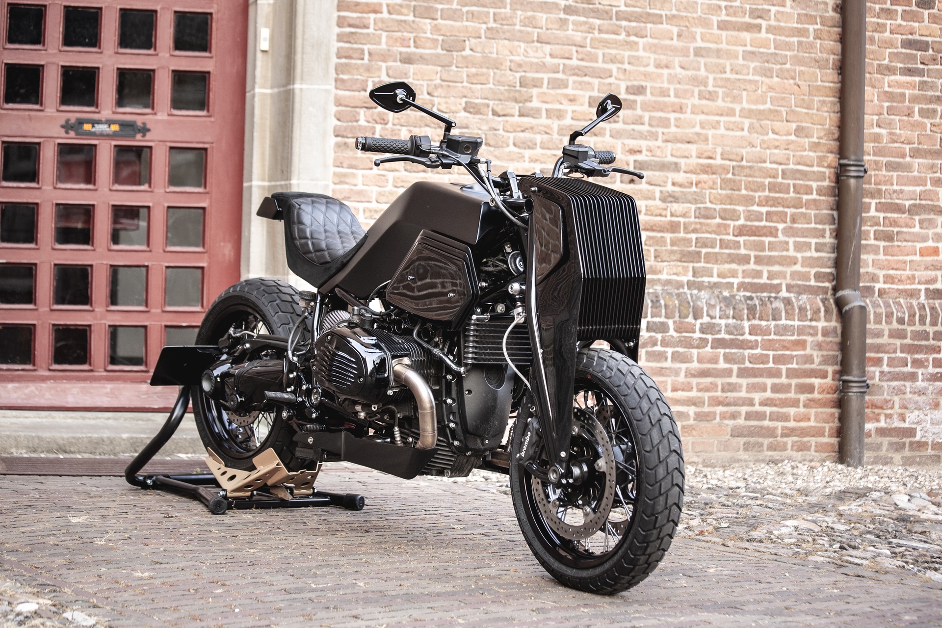 Moto Adonis BMW R nineT Girder custom motorcycle in alley near brick wall