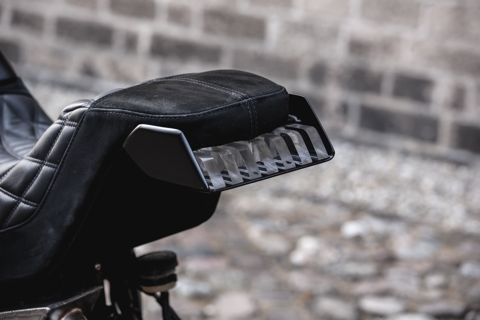 The tail section of Moto Adonis' BMW R nineT 'Girder' custom motorcycle in an alleyway in Amsterdam
