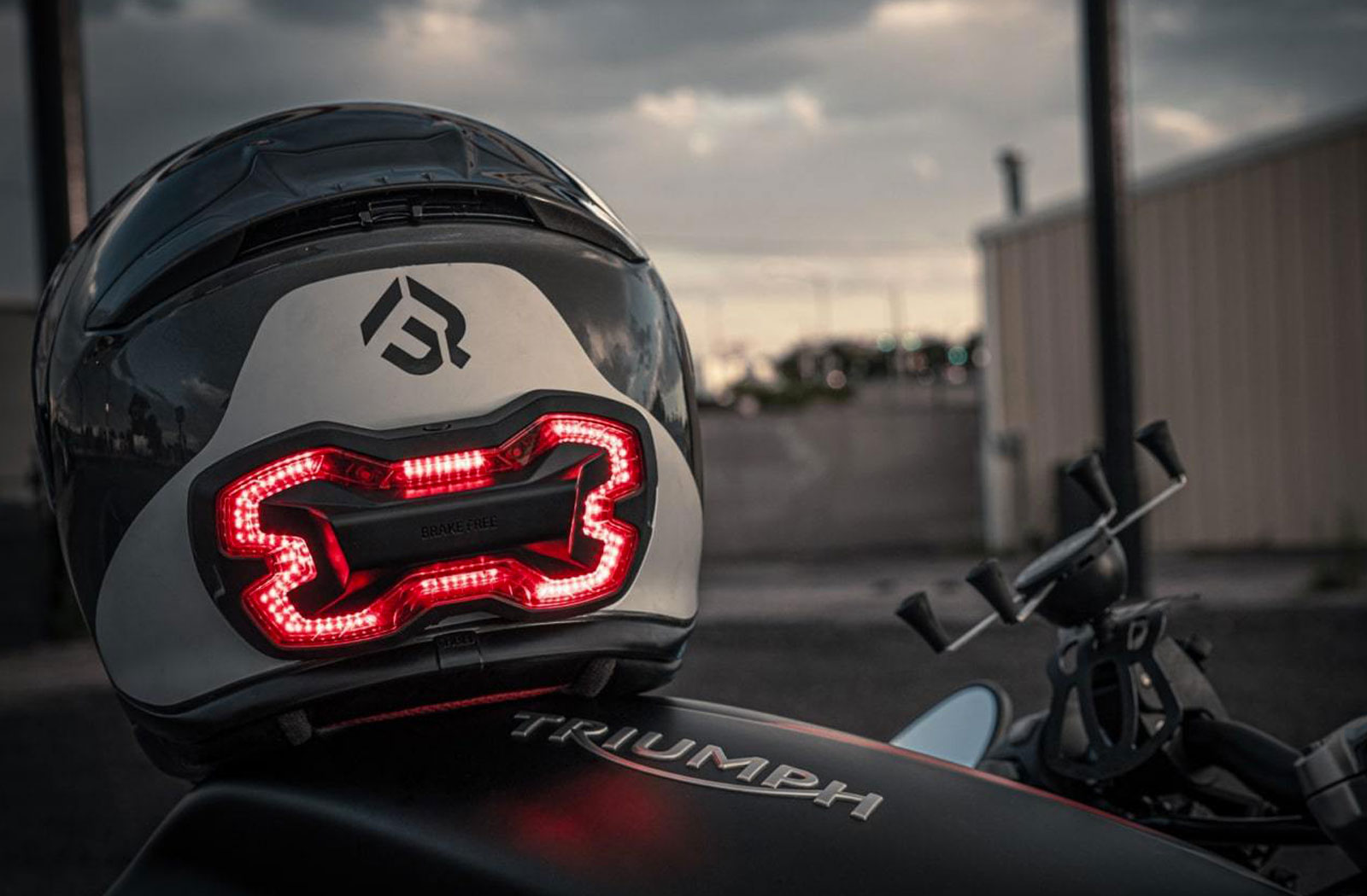 Motorcycle helmet with light on back sitting on Triumph bike
