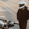 Portrait photo of a person wearing a helmet standing with a motorcycle
