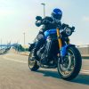 The 2022 Yamaha XSR900 motorcycle - front 3/4 profile as it rides under an overpass