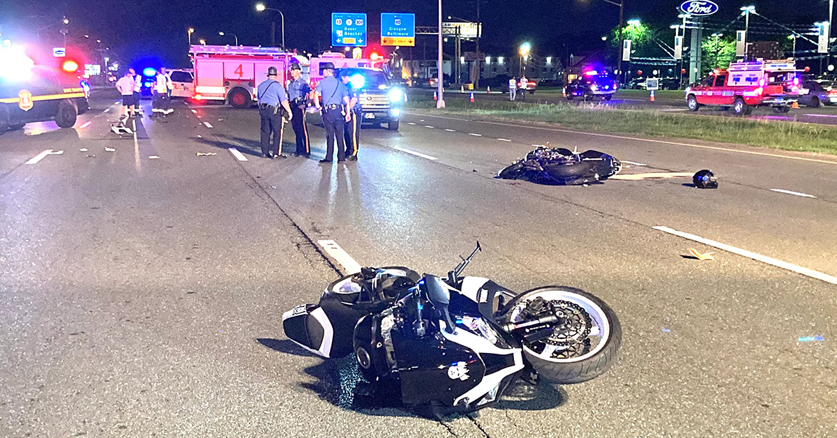 Fatal motorcycle crash scene on city street by night
