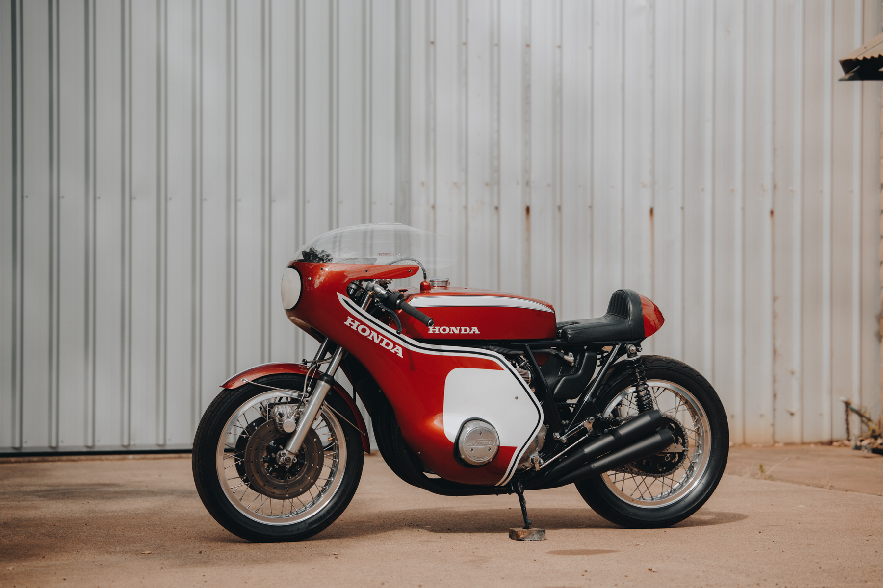Photo of a Honda CR750 motorcycle parked in front of a shed