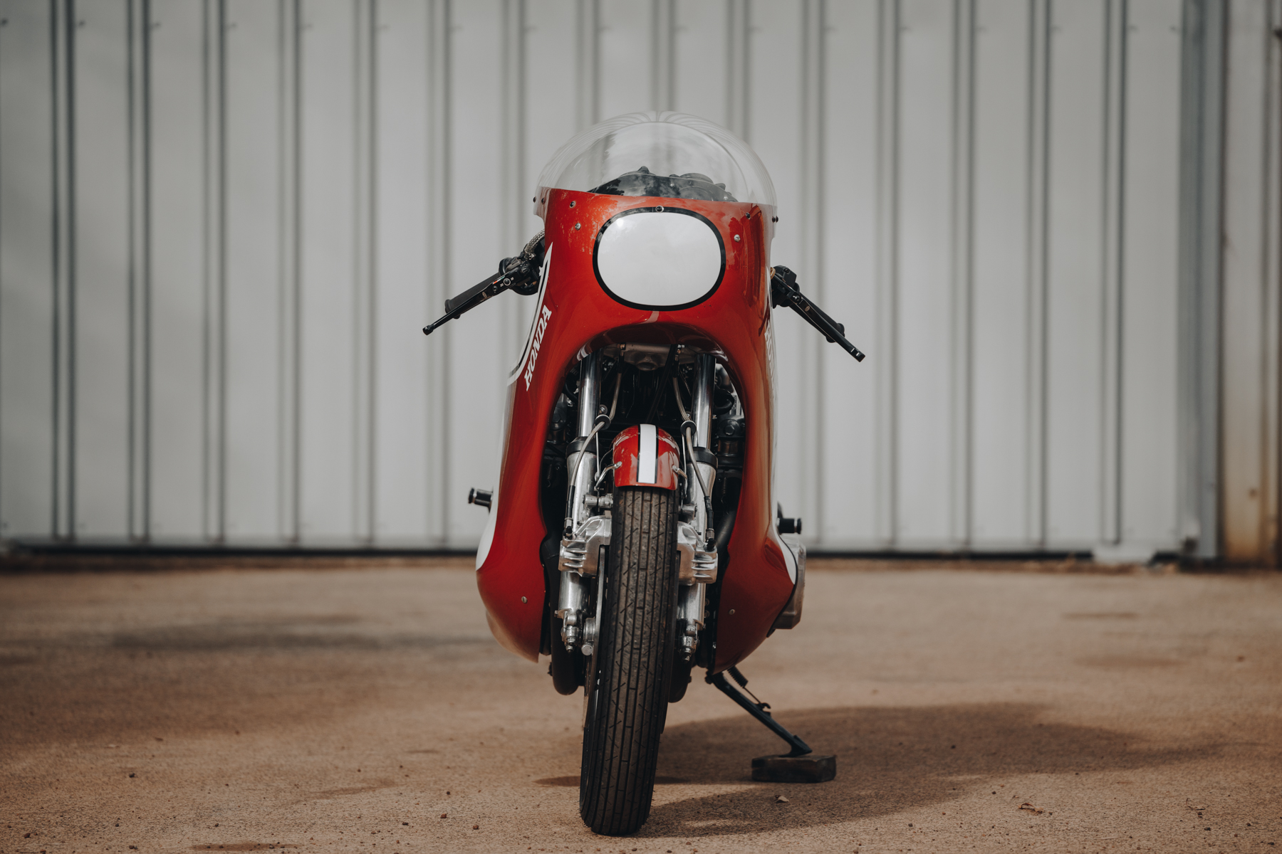 Front photo of a Honda CR750 motorcycle parked in front of a shed