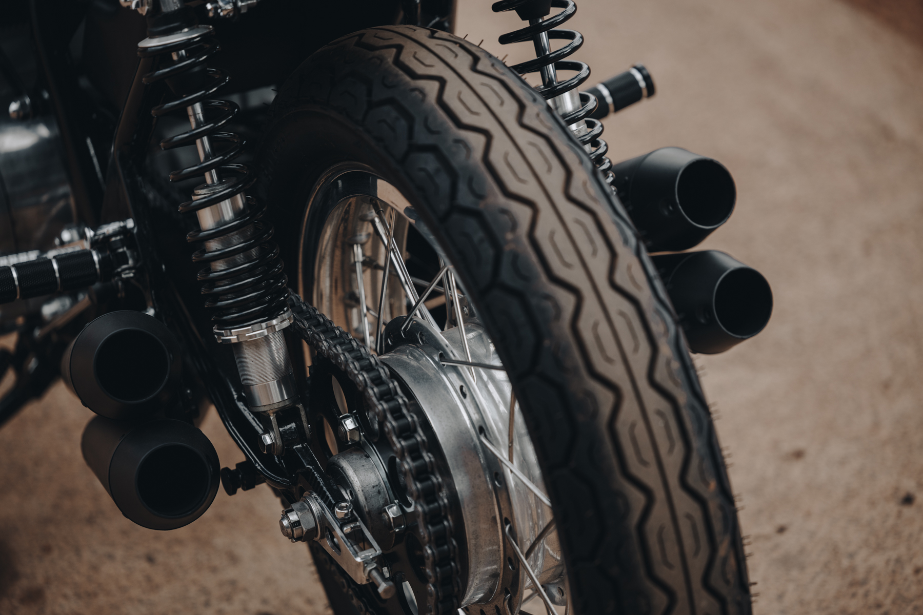 Detail photo of a Honda CB750 rear wheel and exhaust pipes