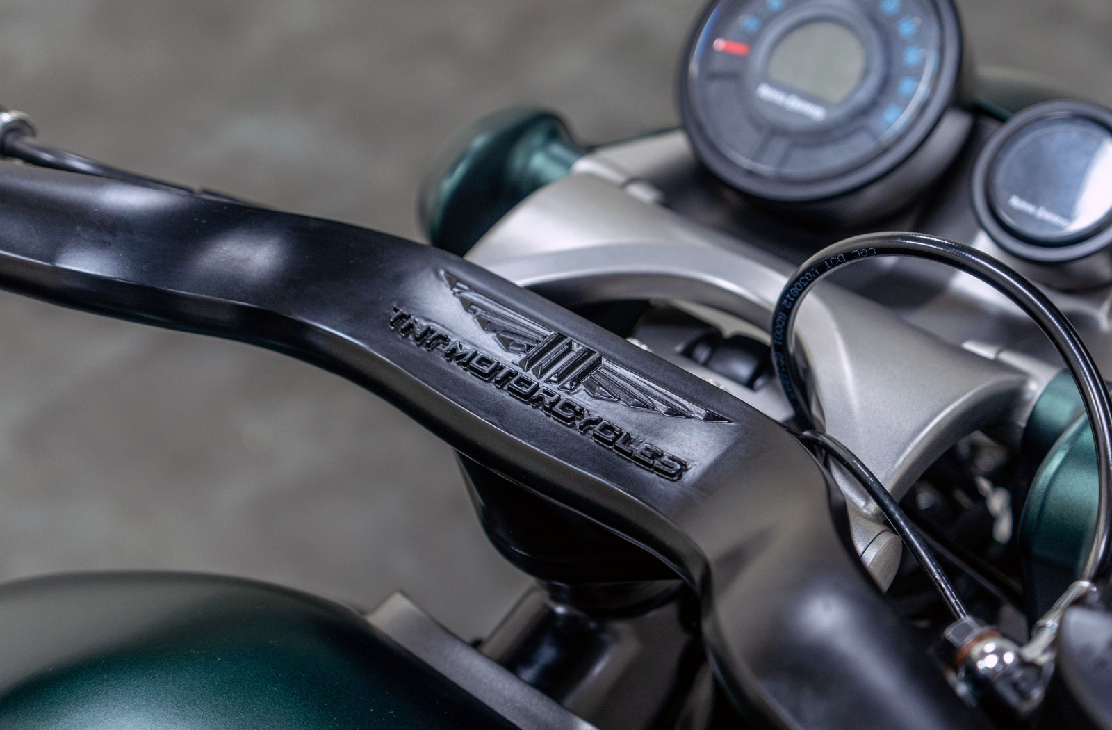 detail photograph of a custom Royal Enfield Shotgun 650 motorcycle handlebar with TNT Motorcycles logo